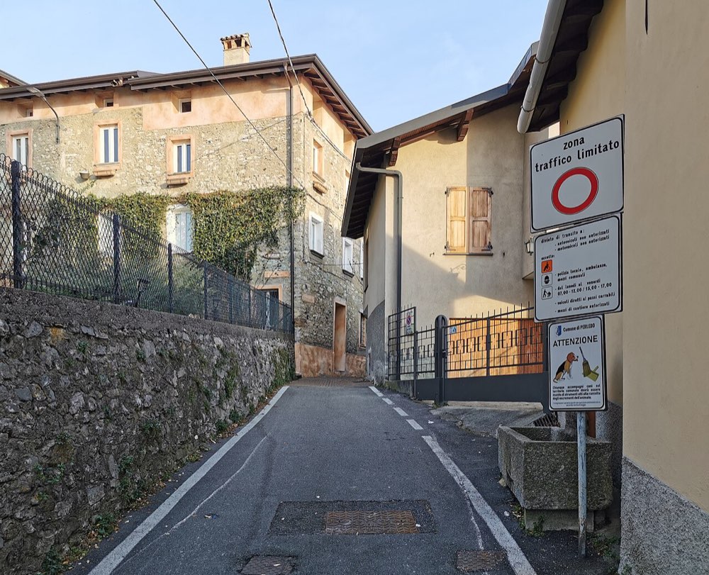 A street sign marking the start of a limited traffic area (ZTL) in an Italian village