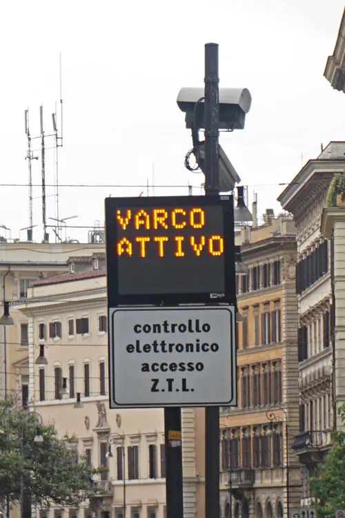 A ZTL gate in Rome: an amber electronic display reading VARCO ATTIVO above a sign reading controllo elettronico accesso Z.T.L., with the camera on the pole above